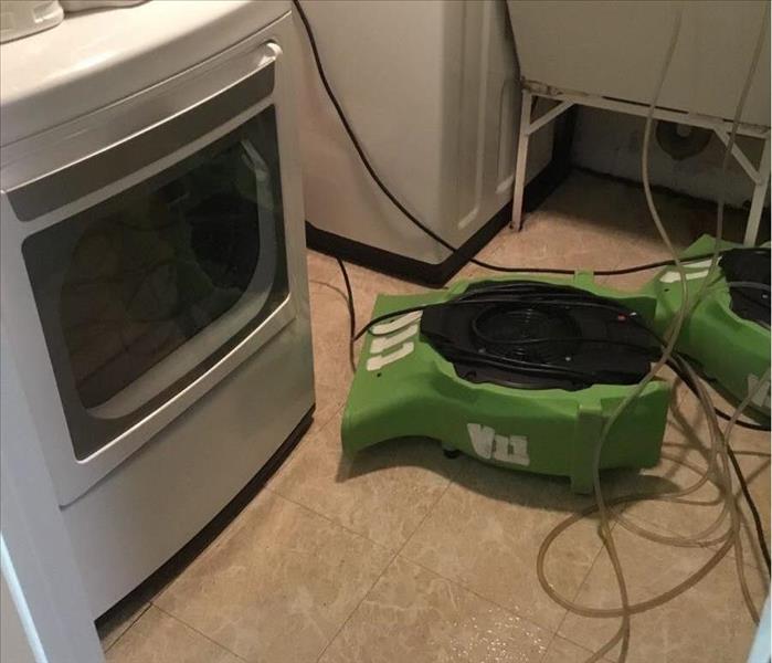 Laundry room with SERVPRO drying equipment on tile floor