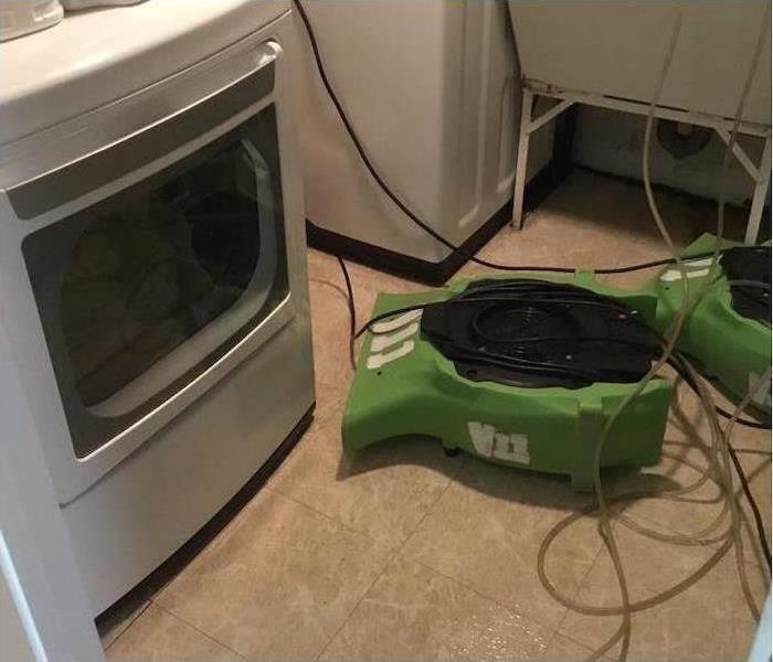 SERVPRO fans on the floor of a water damaged laundry room